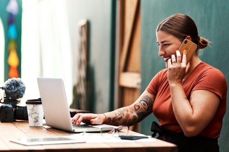 woman with tattoo working on laptop