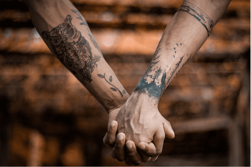tattooed couple holding hands